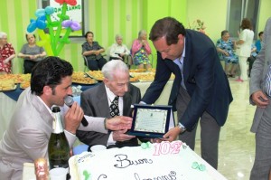 Il sindaco di Rossano, Giuseppe Antoniotti, mentre consegna una targa celebrativa a "nonno Umberto"